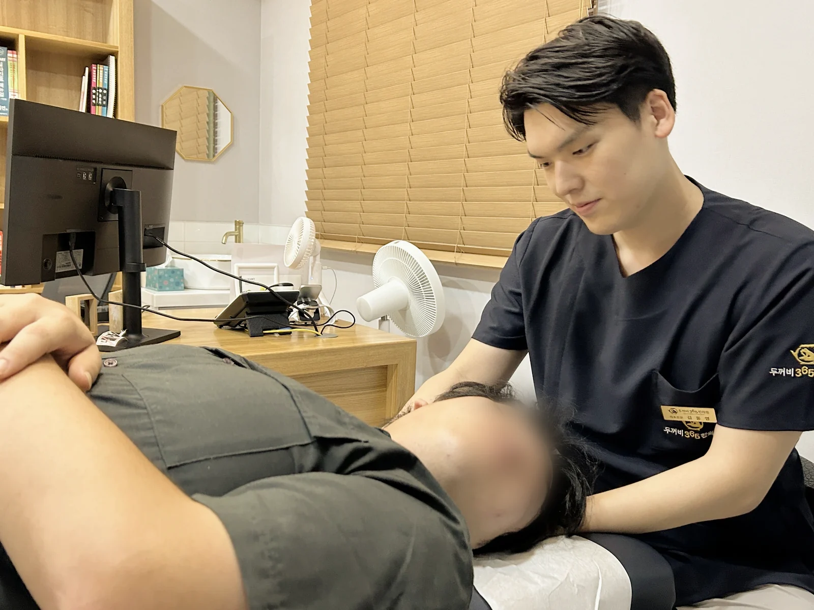 누운 환자의 목을 살피는 원장님